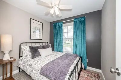 a bedroom with a bed and a window with blue curtains at Ark Adventure Retreat in Walton