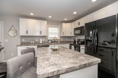 a kitchen with white cabinets and a granite counter top at The Gem Vacation Rental in Walton