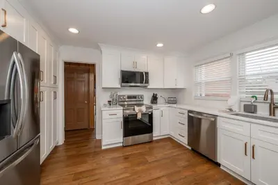 a kitchen with white cabinets and stainless steel appliances at Tallen Manor & Retreat in Hamilton