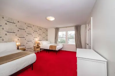 a bedroom with two beds and a red carpet at Tallen Manor & Retreat in Hamilton