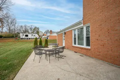 a patio with tables and chairs next to a brick building at Tallen Manor & Retreat in Hamilton