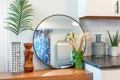 a mirror sitting on top of a wooden table with vases at Merion Village Residences 1164 in Columbus
