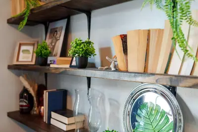 a shelf with books and plants and a mirror at Merion Village Residences 1164 in Columbus