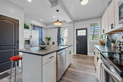 a large kitchen with white cabinets and a black refrigerator at Merion Village Residences 1164 in Columbus