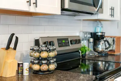 a kitchen counter with a stove with spice jars at Merion Village Residences 1164 in Columbus
