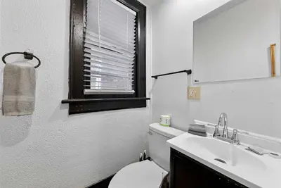a bathroom with a toilet and a sink and a mirror at Merion Village Residences 1166 in Columbus