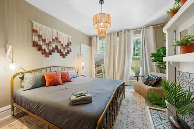a bedroom with a bed and a large window at Merion Village Residences Suites in Columbus