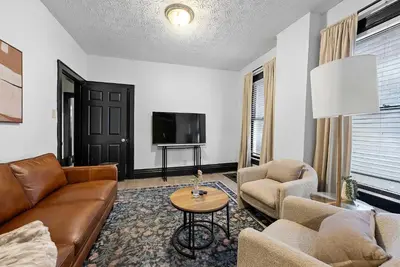 a living room with a couch and chairs and a tv at Merion Village Residences Suites in Columbus