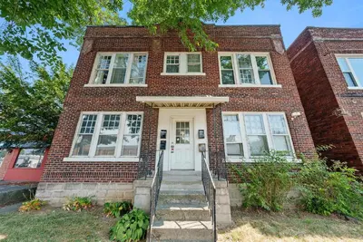 a brick house with a white door and stairs at Merion Village Residences Suites in Columbus