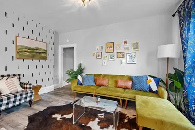 a living room with a green couch and a table at Merion Village Residences Suites in Columbus