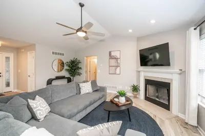 a living room with a gray couch and a fireplace at Poolside Paradise Near the Ark in Walton