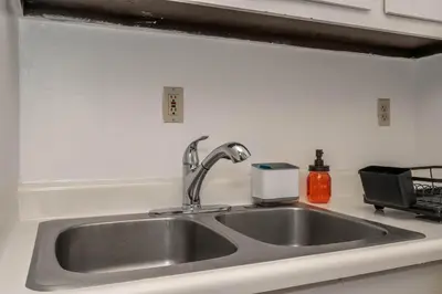 a kitchen sink with a faucet on a counter at Northside Suite 2 - Cozy Escape in Cincinnati