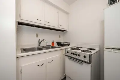 a white kitchen with a sink and a stove at Northside Suite 2 - Cozy Escape in Cincinnati