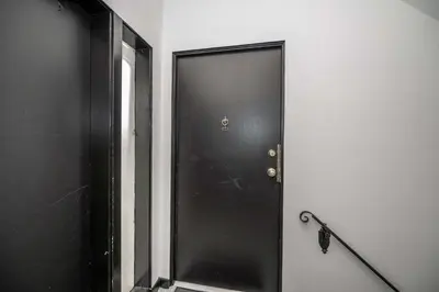 a black door in a white room with a chain at Northside Suite 2 - Cozy Escape in Cincinnati