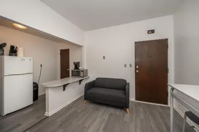 a room with a chair and a desk and a refrigerator at Northside Suite 2 - Cozy Escape in Cincinnati