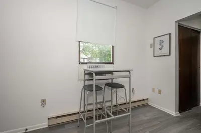 a bar with two stools in a room with a window at Northside Suite 2 - Cozy Escape in Cincinnati
