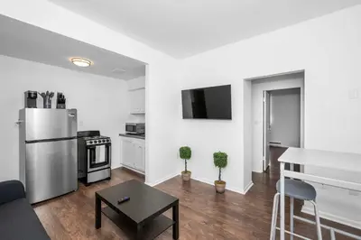 a living room with a refrigerator and a kitchen at Northside Suites 3 - A Chic Relaxed Stay for 2 in Cincinnati