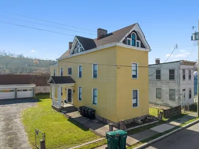 a large yellow house with a roof at Northside Suites 3 - A Chic Relaxed Stay for 2 in Cincinnati