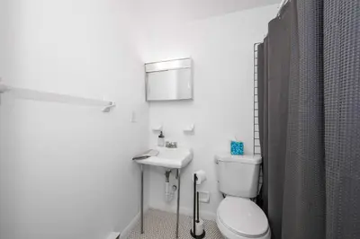 a white bathroom with a toilet and a sink at Northside Suites 3 - A Chic Relaxed Stay for 2 in Cincinnati