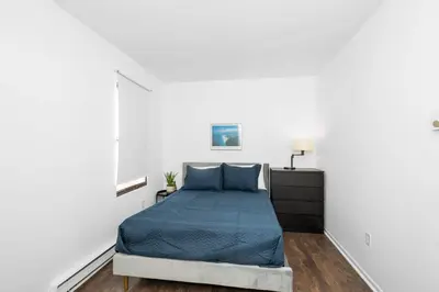 a bedroom with a bed in a white room at Northside Suites 4 - Your Perfect Vacation Haven in Cincinnati