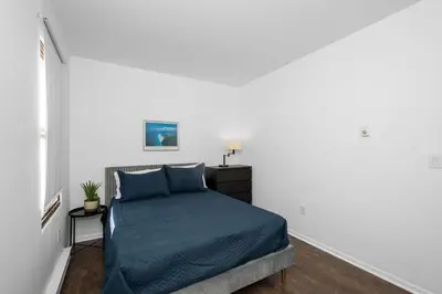 a bedroom with a bed in a white room at Northside Suites 4 - Your Perfect Vacation Haven in Cincinnati