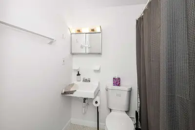 a white bathroom with a toilet and a sink at Northside Suites - 4 Apartments in Cincinnati