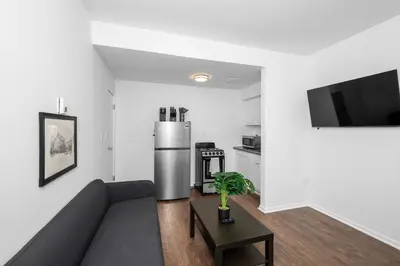 a living room with a couch and a refrigerator at Northside Suites - 4 Apartments in Cincinnati