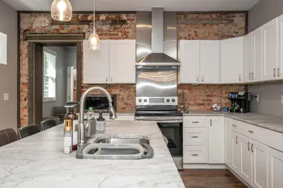 a kitchen with white cabinets and a counter with a sink at The Ruth House - Historic 4 BDR in Cincinnati