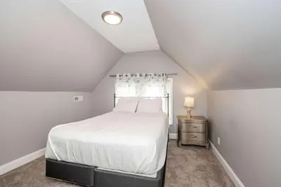 a bedroom with a white bed and a window at The Ruth House - Historic 4 BDR in Cincinnati