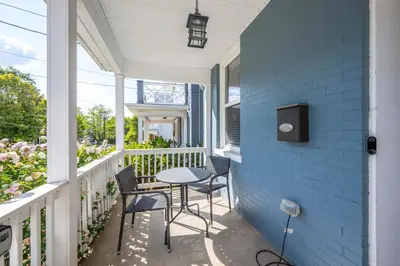 a porch with a table and chairs on a blue wall at The Ruth House - Historic 4 BDR in Cincinnati