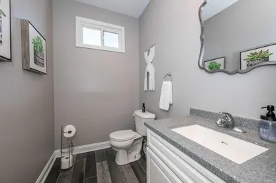 a bathroom with a sink and a toilet and a mirror at The Ruth House - Historic 4 BDR in Cincinnati