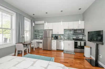 a kitchen with white cabinets and stainless steel appliances at Findlay Market Suite 2 - For 2 in Cincinnati