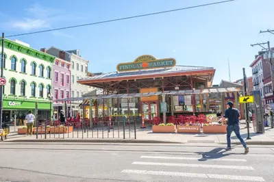 a man crossing a street in front of a building at Findlay Market Suite 2 - For 2 in Cincinnati