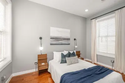 a bedroom with a bed and two windows at Findlay Market Suite 6 - For 4 in Cincinnati