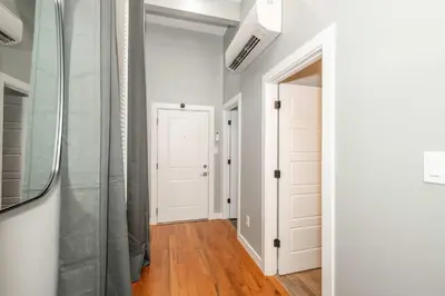 a hallway with white walls and a glass door at Findlay Market Suites - 6 in 1 in Cincinnati