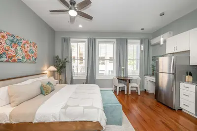a bedroom with a bed and a table and a kitchen at Findlay Market Suites - 6 in 1 in Cincinnati