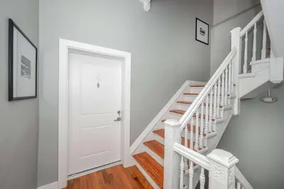 a white hallway with a white door and stairs at Findlay Market Suites - 6 in 1 in Cincinnati