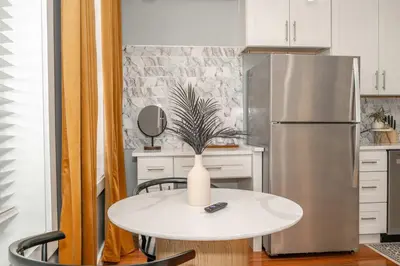 a kitchen with a white table and a refrigerator at Findlay Market Suites - 6 in 1 in Cincinnati