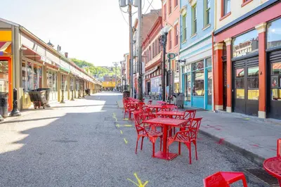 a row of red tables and chairs on a city street at Findlay Market Suites - 6 in 1 in Cincinnati