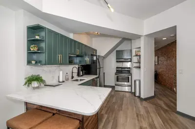 a kitchen with green cabinets and a white counter top at Mansfield Retreat - A Chic Downtown Experience in Cincinnati