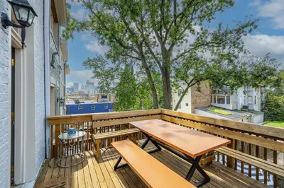 a wooden balcony with a table and benches on it at Mansfield Retreat - A Chic Downtown Experience in Cincinnati