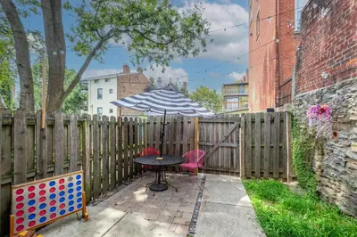 a table with an umbrella next to a fence at Mansfield Retreat - A Chic Downtown Experience in Cincinnati
