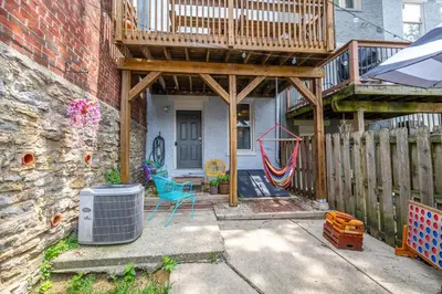 a patio with a deck and a wooden fence at Mansfield Retreat - A Chic Downtown Experience in Cincinnati