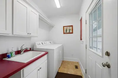 a white kitchen with a sink and a washing machine at Classic Charm on Ashland - For 8 in Columbus