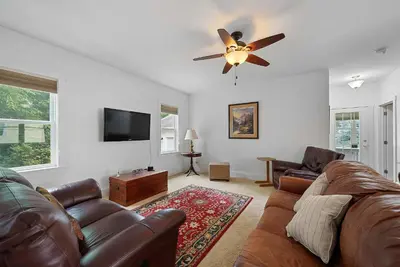 a living room with a couch and a ceiling fan at Classic Charm on Ashland - For 8 in Columbus