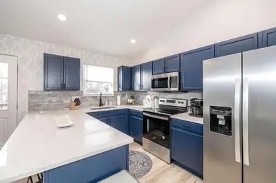 a kitchen with blue cabinets and a stainless steel refrigerator at Walton Arkside Oasis in Walton
