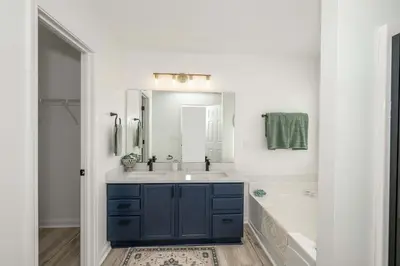 a bathroom with a blue cabinet and a tub and sink at Walton Arkside Oasis in Walton