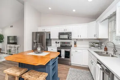 a kitchen with white cabinets and a wooden table at Crittenden Ark Haven in Crittenden