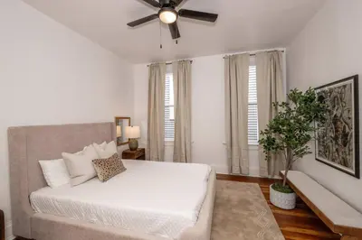 a white bedroom with a bed and a ceiling fan at Woodburn Villa by Blackhouse in Cincinnati