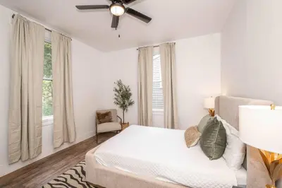 a white bedroom with a bed and a ceiling fan at Woodburn Villa by Blackhouse in Cincinnati